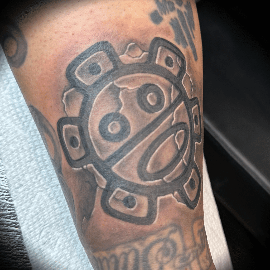 Black and grey stone-etched Taino sun