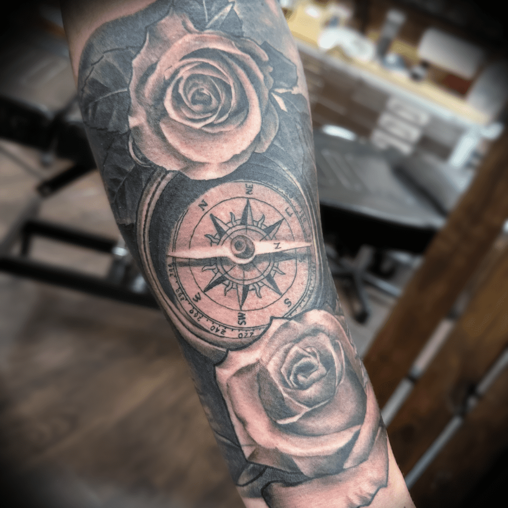 Black and grey realism tattoo of roses and compass